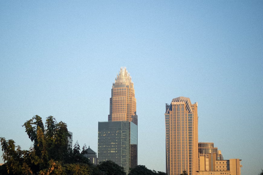 
A person is chained by the ankle to a large spiky ball labeled "DEBT," trying to walk away with clenched fists and a determined expression.